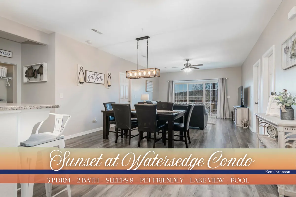 An inviting dining area featuring a stylish dining table, a chandelier above, and expansive windows that frame the shimmering lake beyond. The space is filled with natural light and set up for shared meals and gatherings with friends and family.