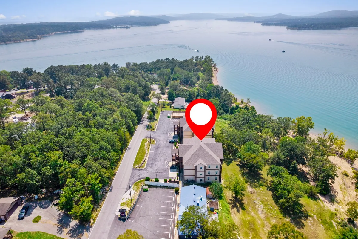 A welcoming lakeside building nestled among lush greenery, with the lake stretching out beside it. The image balances the built environment with natural beauty, suggesting a resort-style experience where guests can relax by the water or embark on outdoor adventures.