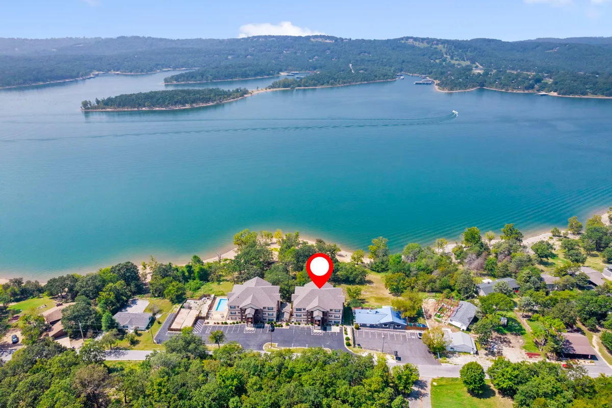 A tranquil lake view with residential buildings in the background, surrounded by greenery. The calm water and natural setting highlight opportunities for boating, swimming, and picnicking, while also evoking peaceful relaxation.