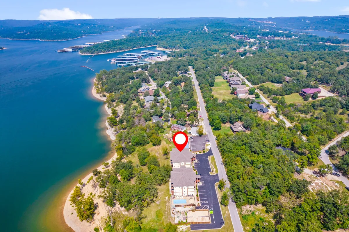 A scenic view featuring the waterfront, abundant greenery, and the nearby marina. The setting highlights boating activities and the lively atmosphere around the marina, conveying easy access for boaters and those interested in exploring the lake.